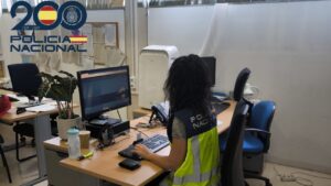 Oficina de la Polic&iacute;a Nacional con una agente trabajando en un ordenador