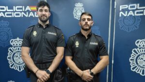 Dos polic&iacute;as nacionales en pr&aacute;cticas en una conferencia de prensa