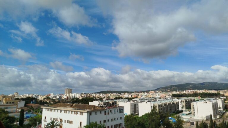 Vista panor&aacute;mica de la ciudad con nubes y cielo azul