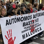 Manifestantes autonomos sosteniendo un cartel en una protesta en Mallorca