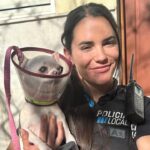 Agente sosteniendo a una perra rescatada de un incendio