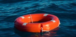 Un salvavidas naranja flotando en el agua azul