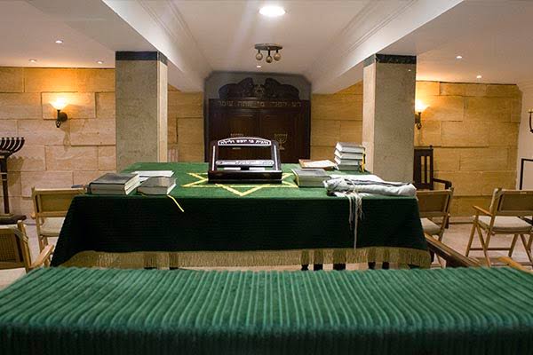 Interior de una sinagoga en Palma con libros y mesa de oración