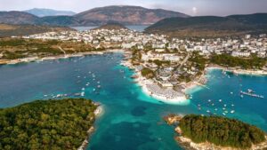 Vista a&eacute;rea de una playa con islotes y embarcaciones en el agua.