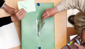Personas votando en las elecciones andaluzas con sobres de votaci&oacute;n