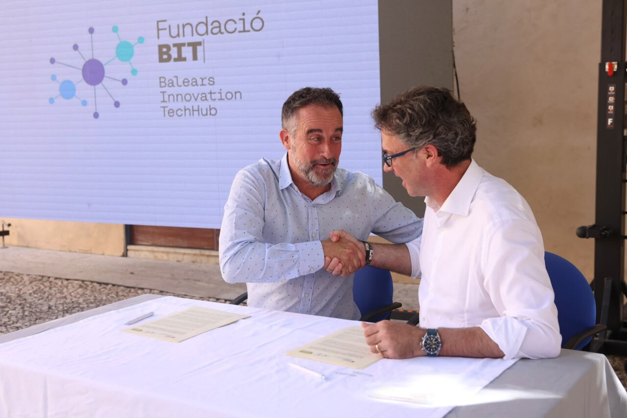 Dos hombres estrechando manos en un evento relacionado con vivienda en ParcBit