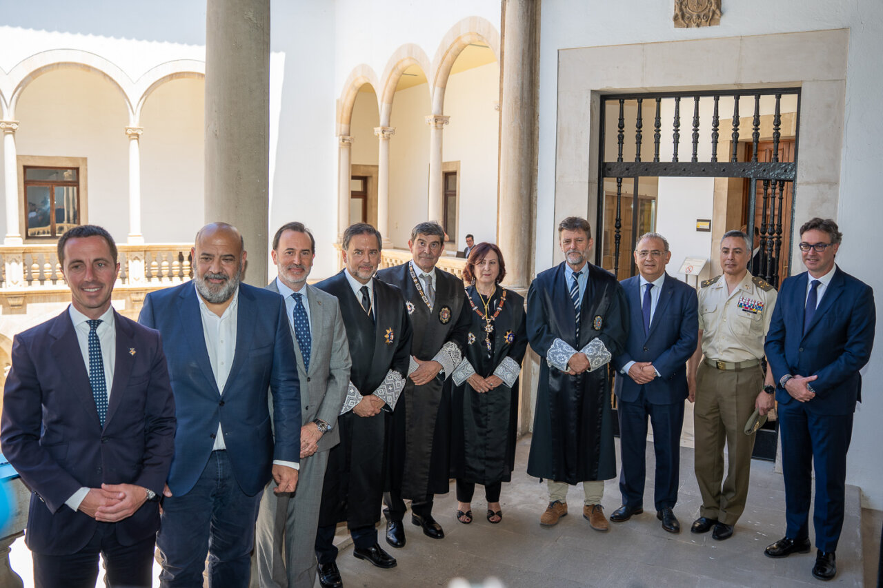 Grupo de personas en un evento formal con togas en un patio