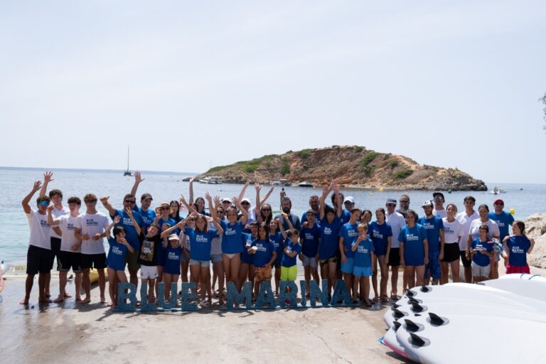 Grupo de personas en el Blue Marina Day en Puerto Portals junto al mar.