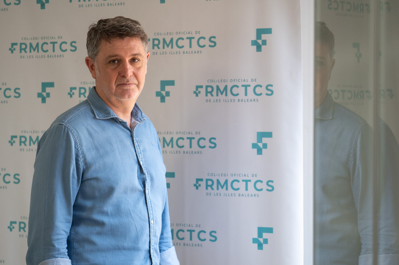 Hombre posando frente a un fondo del Colegio Oficial de Farmac&eacute;uticos