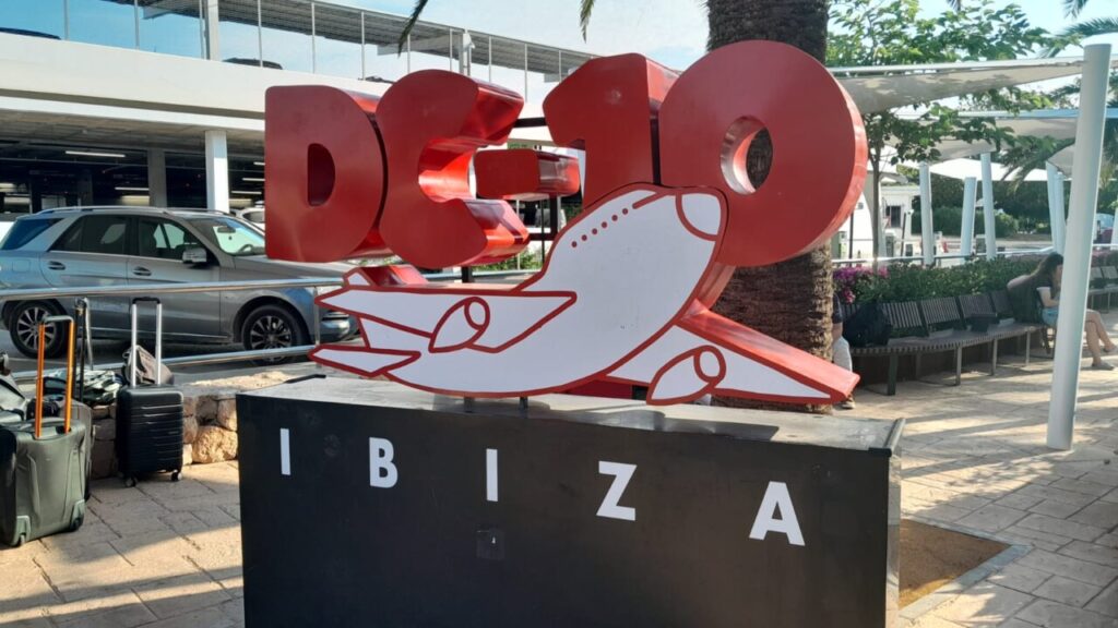 Cartel de publicidad en el aeropuerto de Ibiza con un avión y el texto DC-10