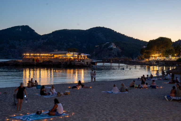 Vista nocturna de la playa de Camp de Mar con gente disfrutando