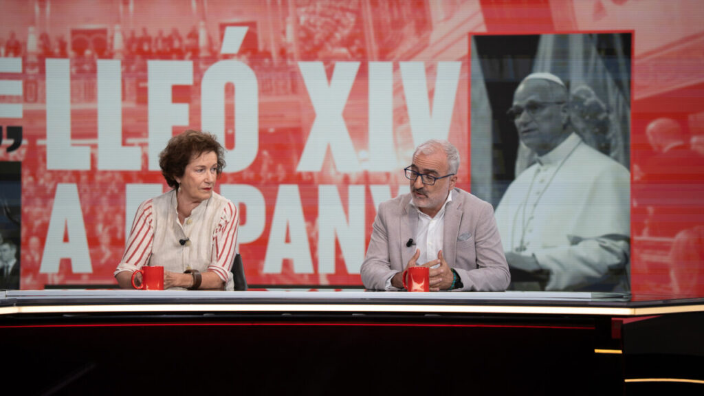 Dos presentadores discutiendo en un programa de televisión con fondo colorido.