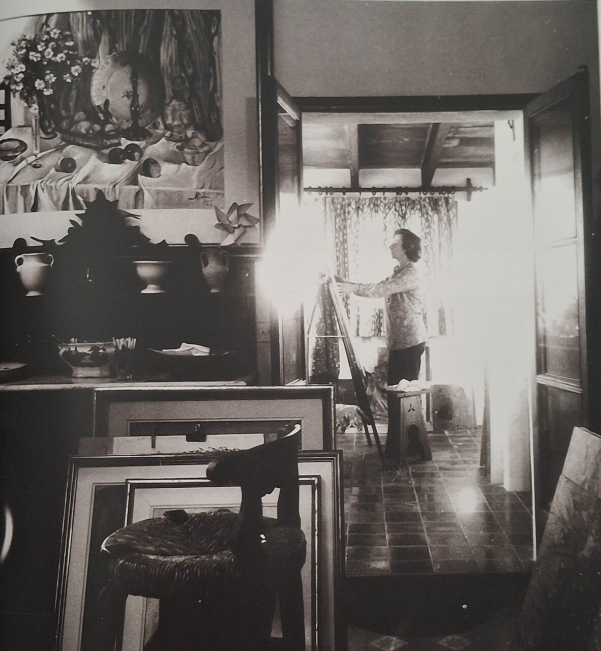 Mujer pintando en un estudio con cuadros y decoraciones