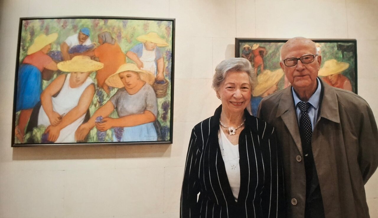 Mar&iacute;a Vich y un hombre sonrientes en una galer&iacute;a de arte.