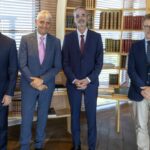 Cuatro ejecutivos posando en un entorno de oficina moderna