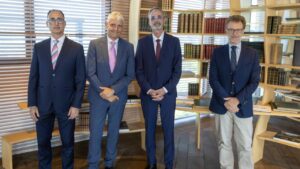 Cuatro ejecutivos posando en un entorno de oficina moderna