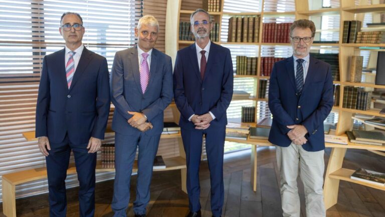 Cuatro ejecutivos posando en un entorno de oficina moderna