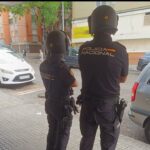 Dos agentes de la Polic&iacute;a Nacional en una calle observando un veh&iacute;culo