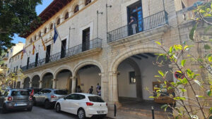 Fachada del Ayuntamiento de Alar&oacute; con veh&iacute;culos estacionados