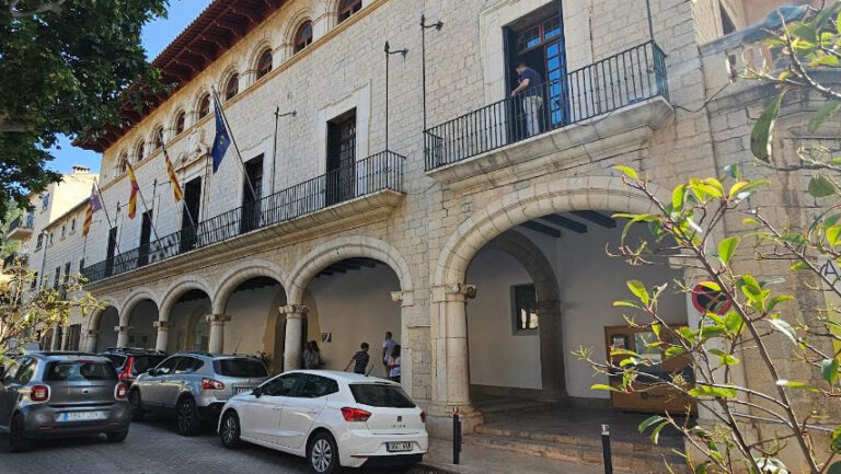 Fachada del Ayuntamiento de Alaró con vehículos estacionados