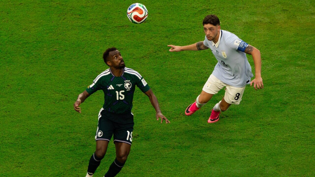 Jugadores de Arabia Saudita y Uruguay compiten por el bal&oacute;n en un partido