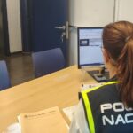 Oficial de polic&iacute;a trabajando en un escritorio con documentos