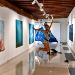 Carol Romero saltando emocionada en su exposici&oacute;n de arte