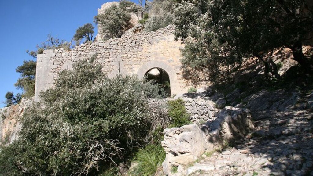 Vista del Castillo de Alar&oacute; rodeado de vegetaci&oacute;n en Mallorca