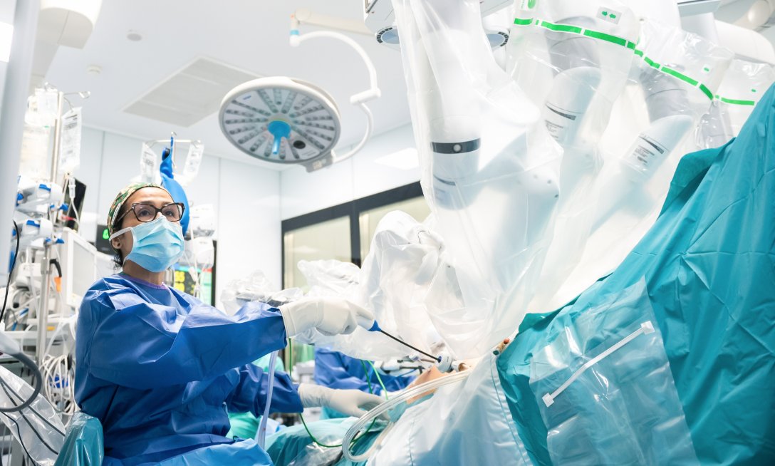 Médico realizando cirugía robótica en un quirófano moderno