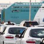 Colas de coches en el puerto de Mallorca con un ferry de fondo