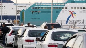 Colas de coches en el puerto de Mallorca con un ferry de fondo