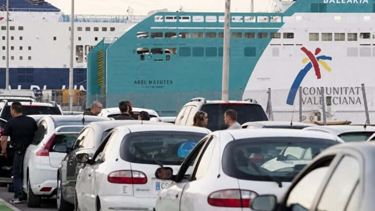 Colas de coches en el puerto de Mallorca con un ferry de fondo
