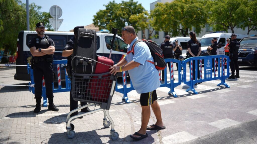 Hombre con carrito de equipaje durante desalojo en Palma