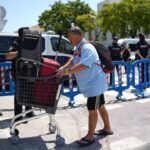 Hombre con carrito de equipaje durante desalojo en Palma