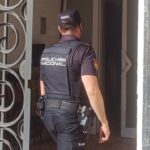 Agente de la Policía Nacional en la entrada de una vivienda durante una intervención