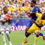 Portero ecuatoriano atrapando el balón en un partido de fútbol