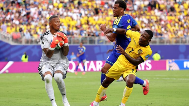 Portero ecuatoriano atrapando el balón en un partido de fútbol
