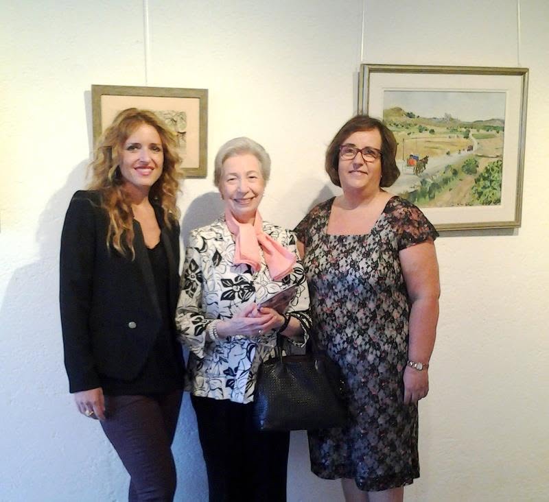 Tres mujeres posando en una galer&iacute;a de arte con pinturas al fondo.