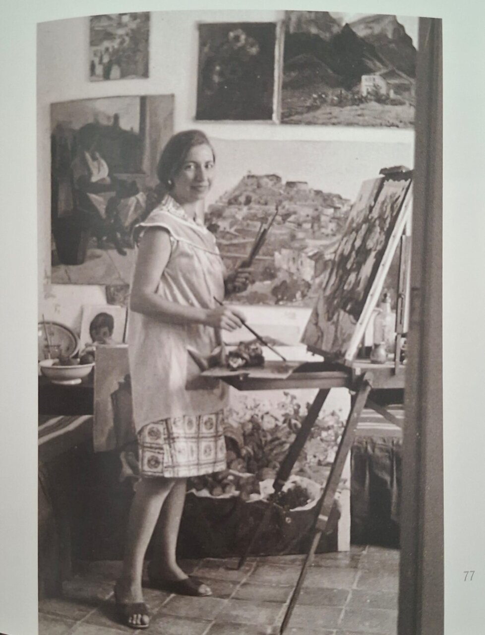 Mar&iacute;a Vich pintando en su estudio con obras en el fondo