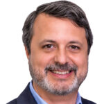 Retrato de un hombre con barba y cabello corto sonriendo