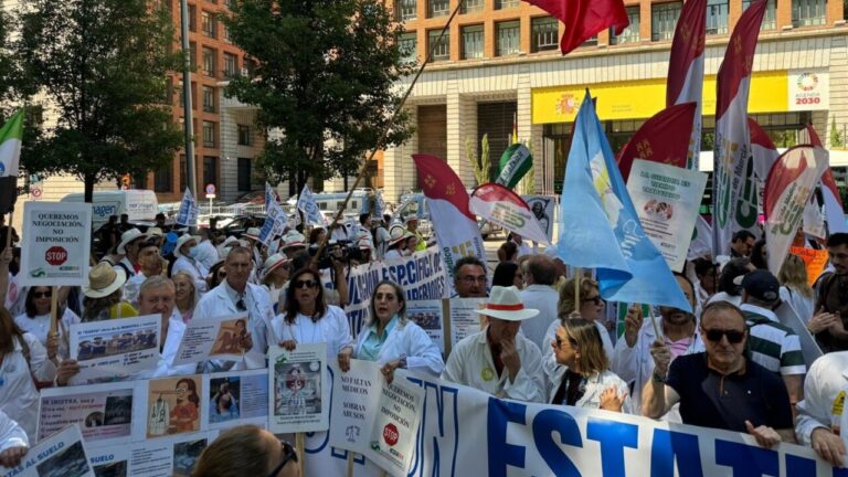 Médicos en huelga sosteniendo pancartas y banderas en una manifestación