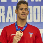 Hugo Gonz&aacute;lez sosteniendo una medalla en un campeonato de nataci&oacute;n