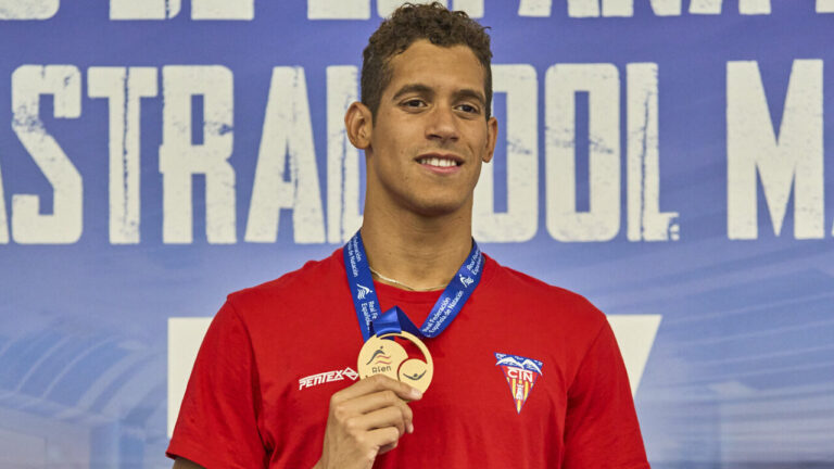 Hugo Gonz&aacute;lez sosteniendo una medalla en un campeonato de nataci&oacute;n