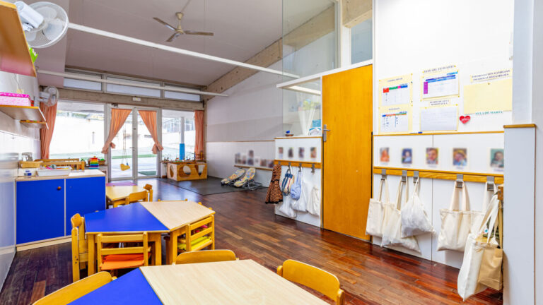 Interior de una escuela con mesas y sillas de colores