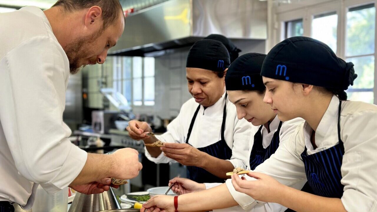 Chef y estudiantes en cocina preparando platos en formaci&oacute;n profesional