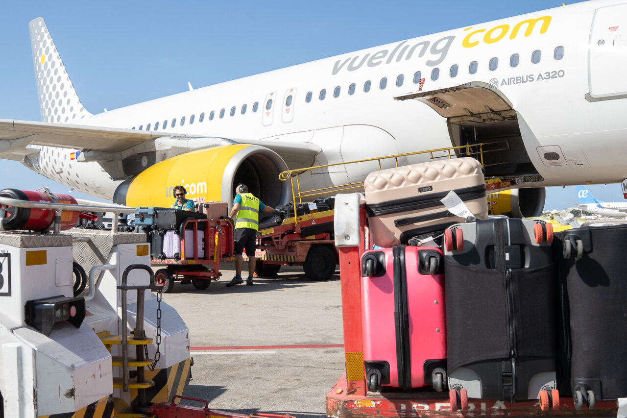 Carga de maletas en el aeropuerto junto a un avión de Vueling