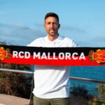 Luis Garc&iacute;a sosteniendo una bufanda del RCD Mallorca frente al mar