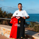 Luis Garc&iacute;a sosteniendo la camiseta del Mallorca frente al mar