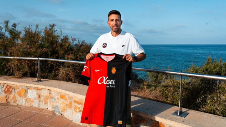 Luis Garc&iacute;a sosteniendo la camiseta del Mallorca frente al mar