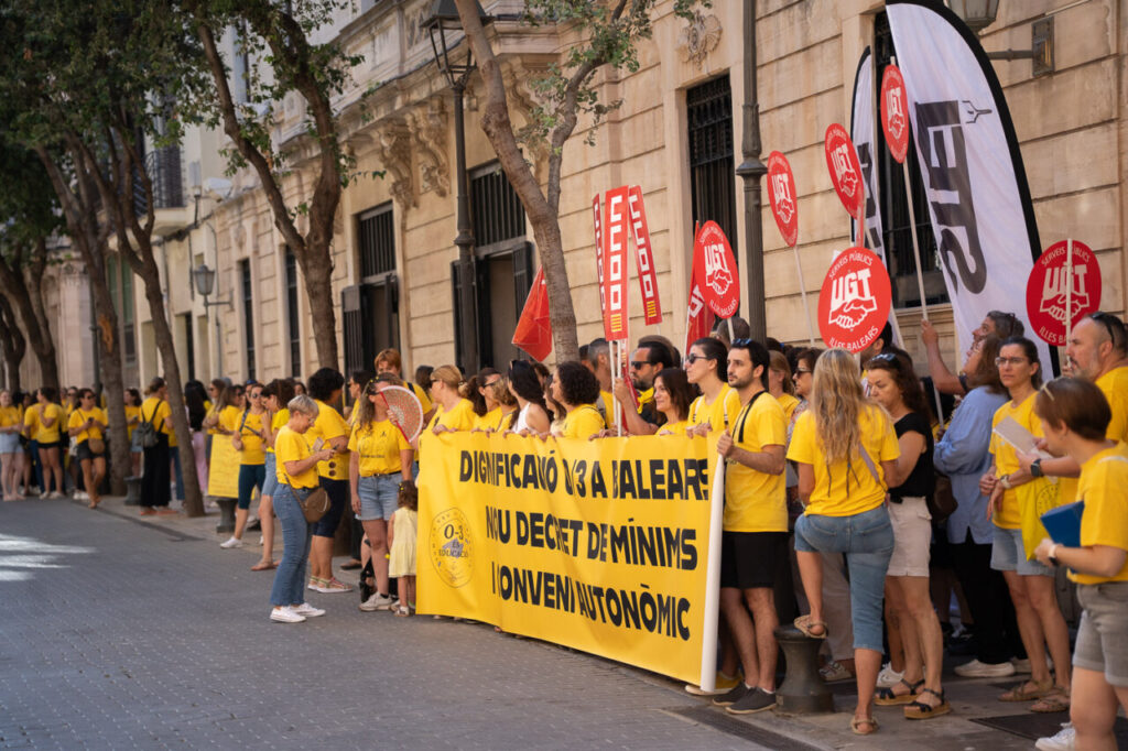 Grupo de personas en una manifestaci&oacute;n con camisetas amarillas y pancartas